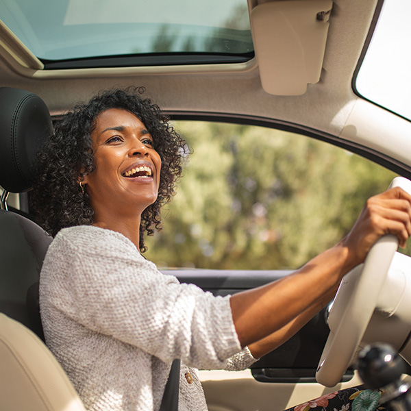 Happy woman smiling and driving